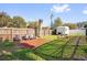 Serene backyard featuring a wooden fence, mature trees, and a cozy fire pit area at 621 Avocado St, St Cloud, FL 34769