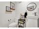 Modern bathroom with toilet, vanity with sink, decor, and a round mirror at 621 Avocado St, St Cloud, FL 34769
