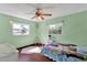 Charming bedroom featuring wood floors, windows allowing ample natural light, and a ceiling fan at 621 Avocado St, St Cloud, FL 34769