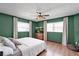 Bright bedroom with neutral decor, hardwood floors, a ceiling fan, and two bright windows at 621 Avocado St, St Cloud, FL 34769