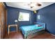 Cozy blue bedroom with bed, window, ceiling fan and closet at 621 Avocado St, St Cloud, FL 34769