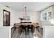 Dining room featuring a wooden table with black chairs, a modern chandelier, and wood-look floors at 621 Avocado St, St Cloud, FL 34769