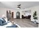 Cozy living room with wood-look floors, a ceiling fan, and a comfortable blue sofa at 621 Avocado St, St Cloud, FL 34769