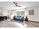 Open-concept living space featuring wood-look floors, a comfortable sofa, and an adjacent dining area at 621 Avocado St, St Cloud, FL 34769