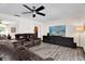 Comfortable living room with a ceiling fan, sleek TV console, and plush leather seating at 621 Avocado St, St Cloud, FL 34769