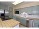 Well-lit kitchen featuring stainless steel appliances, tiled countertops, custom cabinets, and an open, airy design at 10 Massachusetts Ave, St Cloud, FL 34769