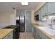Bright kitchen with stainless steel appliances, custom cabinetry, tiled countertops, and access to dining area at 10 Massachusetts Ave, St Cloud, FL 34769
