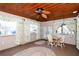 Cozy sunroom with a wood plank ceiling, decorative ceiling fan, dining set, and large windows for natural light at 10 Massachusetts Ave, St Cloud, FL 34769