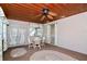 Inviting sunroom featuring a wood plank ceiling, decorative ceiling fan, and dining set, perfect for relaxation at 10 Massachusetts Ave, St Cloud, FL 34769