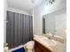 Neutral-toned bathroom featuring a single sink, granite countertop, shower with gray curtain, toilet, and tile flooring at 1228 Haines Dr, Winter Haven, FL 33881
