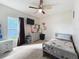 Cozy bedroom with ceiling fan, dresser, a mounted television, and light gray furniture at 1228 Haines Dr, Winter Haven, FL 33881