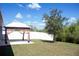 View of the yard with a gazebo and a small shade tree against a backdrop of fencing and foliage at 1228 Haines Dr, Winter Haven, FL 33881