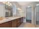 Double sink bathroom featuring dark wood cabinetry, tile floors, and walk-in closet at 1264 Bonita Canyon Dr, Kissimmee, FL 34759