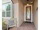 Inviting front entry featuring a decorative glass door, brick flooring, and a comfortable chair at 1264 Bonita Canyon Dr, Kissimmee, FL 34759