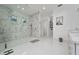 Large walk-in shower with marble-style tilework in a bright and open bathroom at 13049 Sunshine Cir, Clermont, FL 34711