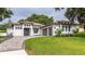 Stunning modern home showcasing a beautiful front lawn, a paver driveway, and a crisp white exterior at 13049 Sunshine Cir, Clermont, FL 34711