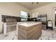 Outdoor kitchen featuring grill, stainless steel refrigerator, island, and tile flooring at 13049 Sunshine Cir, Clermont, FL 34711