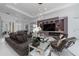 Stylish living area with a large TV, comfortable seating, and sophisticated decor for relaxing and entertaining at 13049 Sunshine Cir, Clermont, FL 34711