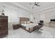 Spacious main bedroom with tufted headboard, tray ceilings, bench, and elegant decor at 13049 Sunshine Cir, Clermont, FL 34711