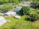 An aerial view of a home, showing the metal roof and large, grassy yard surrounded by mature trees at 1418 Delaware Ave, St Cloud, FL 34769