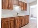 Functional kitchen featuring wood cabinets, a double sink, and durable flooring at 1418 Delaware Ave, St Cloud, FL 34769