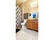 Well-lit bathroom with a tiled floor, a single vanity, and a shower with a patterned curtain at 14620 Golden Rain Tree Blvd, Orlando, FL 32828