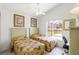 Bedroom with twin beds, window with blinds, and a work area with a chair at 151 Saragossa Ave, Davenport, FL 33897