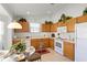 Well-lit kitchen featuring wooden cabinetry, white appliances, tile flooring, and a cozy breakfast nook at 151 Saragossa Ave, Davenport, FL 33897