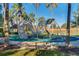Community playground featuring a modern climbing structure with a slide, surrounded by lush greenery and palm trees at 151 Saragossa Ave, Davenport, FL 33897