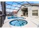Screened-in pool and spa create a luxurious backyard oasis with ample space for relaxation and entertainment at 151 Saragossa Ave, Davenport, FL 33897