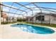 Relaxing screened-in pool and spa surrounded by lush landscaping provides a private backyard oasis at 151 Saragossa Ave, Davenport, FL 33897