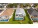 Aerial view of a home with a private screened-in pool and lush green backyard in a residential neighborhood at 153 Laurel Ridge Pass, Davenport, FL 33897