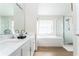 Bright bathroom with a double vanity, separate tub, glass enclosed shower, and wood-look tile flooring at 153 Laurel Ridge Pass, Davenport, FL 33897