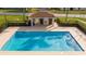 An aerial view of a large pool surrounded by a fence, buildings, and recreational areas at 153 Laurel Ridge Pass, Davenport, FL 33897