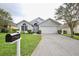 Charming single-story home with a well-maintained lawn, a mailbox, and an attached two-car garage at 153 Laurel Ridge Pass, Davenport, FL 33897