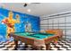 Fun game room with a pool table, foosball table, and unique Star Wars themed wall art at 153 Laurel Ridge Pass, Davenport, FL 33897
