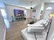 Open-concept living room featuring wood-look flooring, a sectional sofa, and a TV on a media console at 153 Laurel Ridge Pass, Davenport, FL 33897