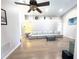 Spacious living room with high ceilings, a ceiling fan, wood-look flooring, and a large sectional sofa at 153 Laurel Ridge Pass, Davenport, FL 33897