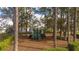 View of a neighborhood playground surrounded by lush greenery and tall trees on a sunny day at 153 Laurel Ridge Pass, Davenport, FL 33897