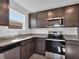 Well-equipped kitchen with stainless steel appliances, granite countertops, and dark wood cabinetry at 1919 Escambia Ln, Kissimmee, FL 34759