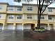 Three-story yellow townhouse with white trim and a private garage at 1960 Legacy Cove Dr # 1960, Maitland, FL 32751