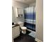 Bright bathroom with a blue striped shower curtain, cabinet, and black tile flooring at 2019 Dixie Belle Dr # 2019L, Orlando, FL 32812