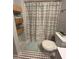 Compact bathroom with gray walls, stylish shower curtain, and unique mosaic tile floor at 2019 Dixie Belle Dr # 2019L, Orlando, FL 32812