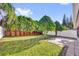 Lush backyard with manicured lawn, mature trees, a brick privacy wall, and a paved patio area at 2450 Parsons Pond Cir, Kissimmee, FL 34743