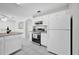 Bright kitchen featuring white cabinets, tile flooring, and modern appliances at 2450 Parsons Pond Cir, Kissimmee, FL 34743