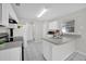 Well-lit kitchen with white cabinets, a breakfast bar, and tile flooring at 2450 Parsons Pond Cir, Kissimmee, FL 34743