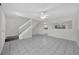 Open-concept living area with tile flooring and a staircase leading upstairs at 2450 Parsons Pond Cir, Kissimmee, FL 34743