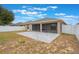 Spacious backyard featuring a stone patio, covered porch, and white fence at 251 Tower View W Dr, Haines City, FL 33844