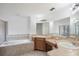 Bathroom featuring double sinks, a bathtub, a shower, and a large mirror at 251 Tower View W Dr, Haines City, FL 33844