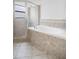 Bathroom featuring tub with tile surround and shower with glass door at 251 Tower View W Dr, Haines City, FL 33844